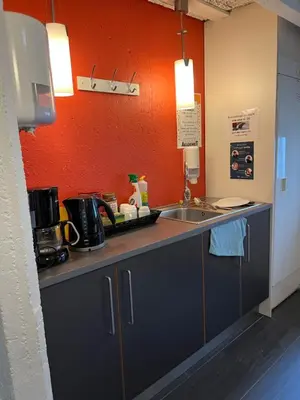 a kitchen with a sink and an orange wall at Raulandsakademiet in Rauland