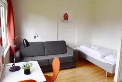 a small living room with a couch and a bed at Raulandsakademiet in Rauland