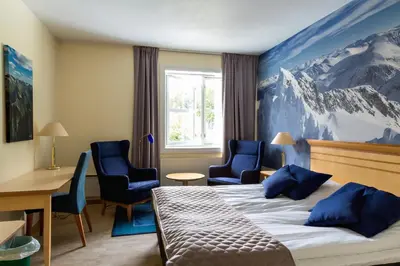 a hotel room with a bed and two chairs at Dreges Hotell - by Classic Norway Hotels in Stranda