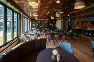 a restaurant with tables and chairs and windows at Dreges Hotell - by Classic Norway Hotels in Stranda