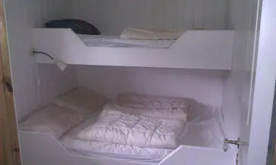 a white closet with two bunk beds in it at Seljestad Cottages in Skare