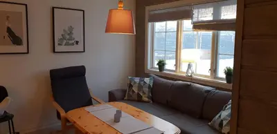 a living room with a couch and a table at Oppdal Alpintun, Stølen øvre - ski in ski out in Oppdal