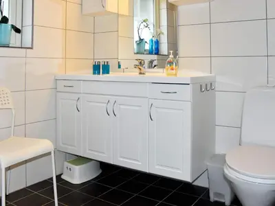 a white bathroom with a sink and a toilet at Seaside Serenity in Leirvik-By Traum in Bø