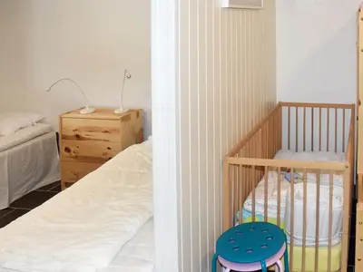 a small bedroom with a crib and a bed at Seaside Serenity in Leirvik-By Traum in Bø