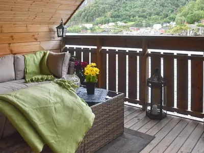 a porch with a couch and a table on a balcony at Seaside Serenity in Leirvik-By Traum in Bø