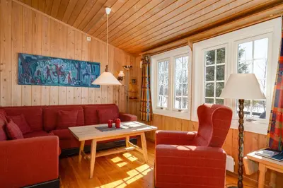 a living room with a couch and a table and two chairs at Bitigrenda I in Beitostøl