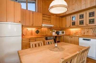 a kitchen with a table and a white refrigerator at Bitigrenda I in Beitostøl