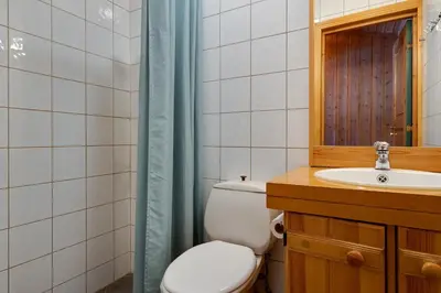 a bathroom with a toilet and a sink and a mirror at Bitigrenda I in Beitostøl