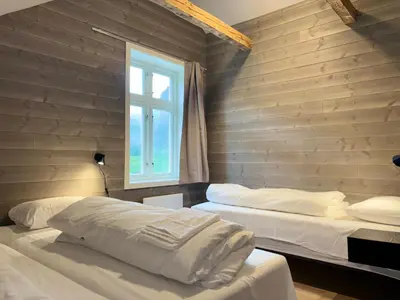 a bedroom with two beds and a window at Brekke Gard Hostel in Flåm