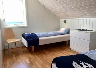 a bedroom with a bed and a desk and a chair at Hindrum Fjordsenter in Vannvikan