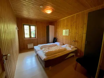 a bedroom with a large bed in a wooden room at Hafjell Grenda lejligheder og hytter in Hafjell