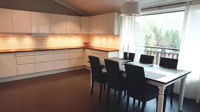 a kitchen with a table with chairs and a window at Otnes Sør - Luxury 140m2 in Aurland