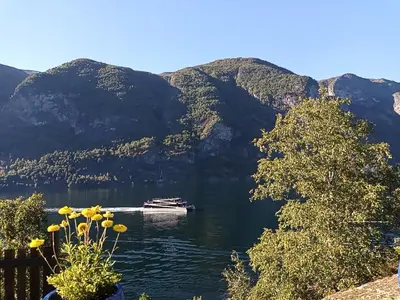 a boat on a lake with mountains in the background at Otnes Sør - Luxury 140m2 in Aurland