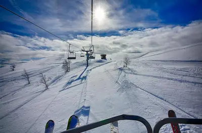 a person riding a ski lift in the snow at Ideal For Families 6 Bedrooms, Hot Tub And Sauna in Beitostøl