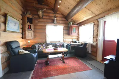 a living room with a couch and a table in a cabin at Ideal For Families 6 Bedrooms, Hot Tub And Sauna in Beitostøl