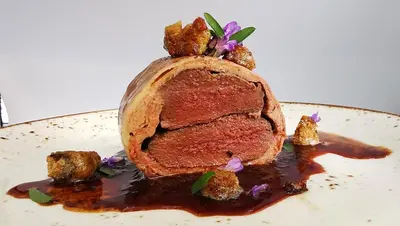 a piece of meat on a plate with sauce at Klingenberg Hotel - Årdal in Årdalstangen