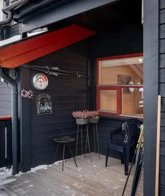 a patio of a restaurant with two chairs and a red awning at Supersentralt ski inn ski out in Geilo