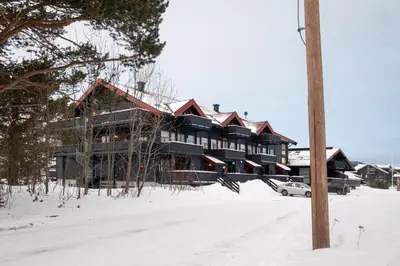 a large house in the snow with a pole at Supersentralt ski inn ski out in Geilo