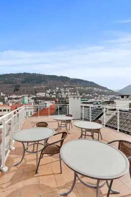 a patio with tables and chairs on a balcony at Apartment Bergen Central in Bergen