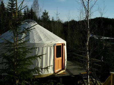 a yurt with a wooden door in a forest at Halvorseth in Prestfoss