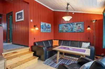 a living room with a table and leather chairs at Bitigrenda B in Beitostøl