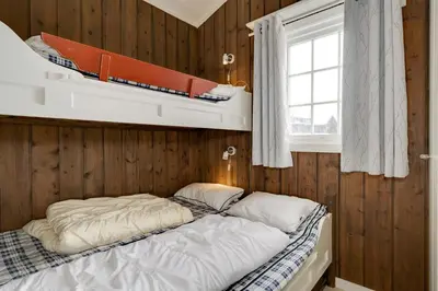 a bedroom with two bunk beds and a window at Bitigrenda G in Beitostøl
