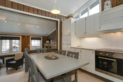 a kitchen and dining room with a table and chairs at Bitigrenda K in Beitostøl