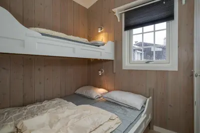 a bedroom with a bunk bed and a window at Bitigrenda L in Beitostøl