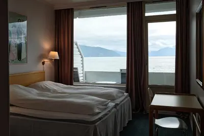 a hotel room with a bed and a large window at Balestrand Hotel in Balestrand