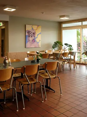 a dining room with tables and chairs and a painting at Balestrand Hotel in Balestrand