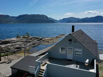 a house on the shore of a body of water at Waerholmen in Lavik