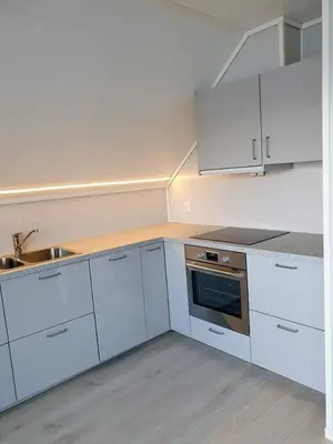a kitchen with white cabinets and a sink at Waerholmen in Lavik