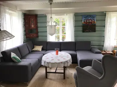 a living room with a couch and a table at Landlig idyll med fjordutsikt in Valsøybotn