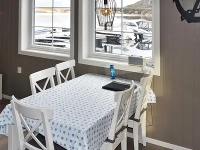 a dining room table and chairs with a table and windows at 6 person holiday home in Oksvoll in Oksvoll