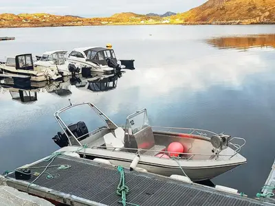 a boat is docked at a dock in the water at 6 person holiday home in Oksvoll in Oksvoll
