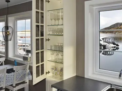 a dining room with a window with wine glasses at 6 person holiday home in Oksvoll in Oksvoll