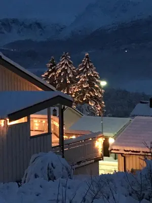 a house with lights in the snow at night at Apartment Dreamvalley in Isfjorden