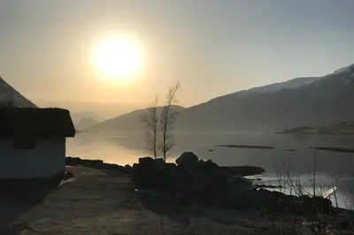 a sun setting over a body of water at Apartment Dreamvalley in Isfjorden