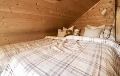 a bedroom with a bed in a wooden room at Gorgeous Home In Norheimsund With Wifi in Norheimsund