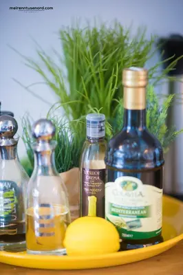 a plate with bottles of oil and lemons on a table at Kalvåg Holidayapartment in Kalvåg