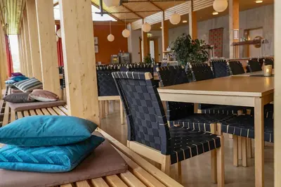 a dining room with a table and chairs with pillows at Unicare Røros in Røros