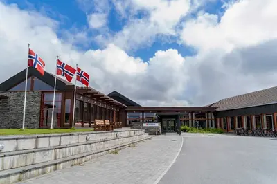 three british flags flying in front of a building at Unicare Røros in Røros