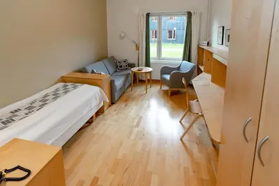 a room with a bed and a couch and a table at Unicare Røros in Røros