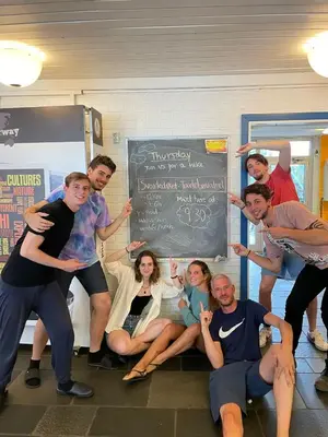 a group of people posing in front of a chalkboard at Bergen Hostel Montana in Bergen