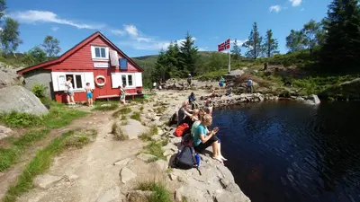 a group of people sitting on the edge of a river at Bergen Hostel Montana in Bergen