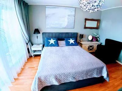 a bedroom with a bed with blue walls at Bjørnestrand Fjordside View in Bergen