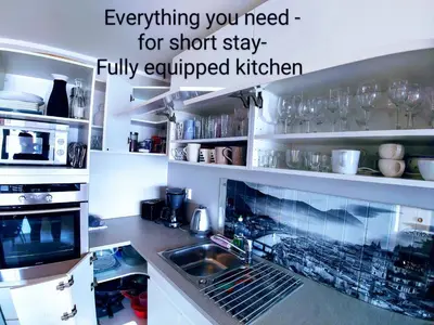a kitchen with a sink and a microwave at Bjørnestrand Fjordside View in Bergen