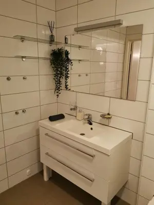 a white bathroom with a sink and a mirror at Bjørnestrand Fjordside View in Bergen