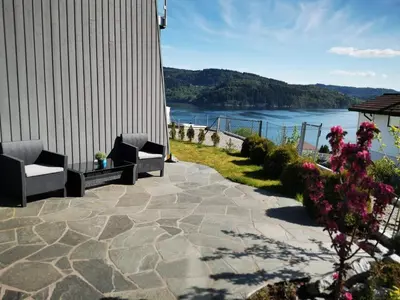 a patio with two chairs and a view of the water at Bjørnestrand Fjordside View in Bergen