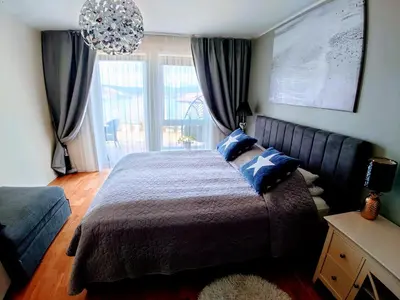 a bedroom with a large bed with blue pillows at Bjørnestrand Fjordside View in Bergen